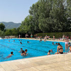 Varios niños en el recinto de las piscinas municipales de la Seu d'Urgell refrescándose en un día de calor extremo