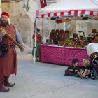 Niños observando a uno de los figurantes vestidos de época en el mercado medieval.