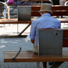 Imatge d’un jubilat assegut en un banc d’un parc.