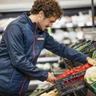 Un treballadors de la cadena de supermercats Aldi en una imatge amb aliments i fruites