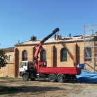 Operarios trabajan en las obras para reformar el tejado de la parroquia de Montserrat de Lleida.