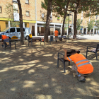 Un grup d’operaris arreglen i repinten els bancs de la plaça de Sant Pere, ahir al Secà.