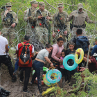 Militars observen migrants que travessen el riu Bravo per intentar entrar als Estats Units.