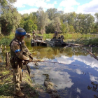 Tropes ucraïneses pesquen i inspeccionen tancs destruïts.