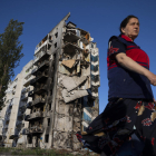 Una dona camina a prop a un edifici destruït a Borodianka.