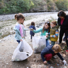 Escolars recullen escombraries al costat del riu a Rialp.