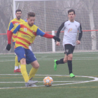 Un jugador del Bellpuig controla la pilota davant de la pressió del rival.