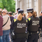 Dos agentes de la Guardia Urbana durante una patrulla por el Eix Comercial durante la Festa Major. 