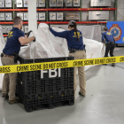 Agents de l’FBI manipulen les restes del globus xinès abatut.