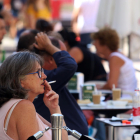 Una mujer fumando en una terraza.