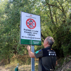 Un Agent Rural obre un cartell de prohibició del pas al Montsec a la zona de Corçà, a Àger, per l'activació del pla Alfa 3.
