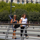 Una mujer cargando ayer un ventilador en Lleida ciudad. 