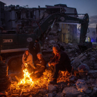 Una familia rodeada de escombros se calienta al raso en la ciudad turca de Antioquia, en el sur del país.