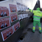 Personal de neteja eliminant pintades i retira cartells contra la cimera a Monjuïc.