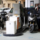El conductor d'una moto posant combustible a la gasolinera del carrer Legalitat de Barcelona.