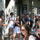 Un grup de joves menja un gelat per refrescar-se a la Rambla de Girona