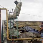 Treballadors extreuen una part d’un coet del sostre d’un edifici atacat a Odessa.