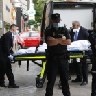 Miembros del servicio funerario trasladan un cadáver de la vivienda sita en el número 205 de la calle Serrano de Madrid, donde este lunes dos mujeres y un hombre de edad adulta han muerto tiroteados.