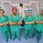 El equipo de urología del hospital Vithas Lleida posa con el robot Da Vinci detrás suyo. 