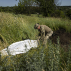 Un militar ucraniano exhuma cuerpos de soldados rusos en Járkov. 