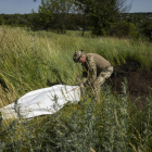 Un militar ucraïnès exhuma cossos de soldats russos a Khàrkiv.