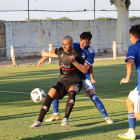 El atacante del Mollerussa Adri Fernández protege la posesión, con Toni Vicente intentando ganarle la posición para robar el balón. 