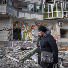 Una mujer camina entre escombros de una casa semidestruida en Jersón.