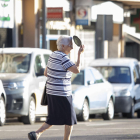 Una dona es protegeix del sol mentre travessa el carrer a Lleida.