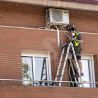 Imatge d'arxiu de tasques de reparació d'un aparell d'aire condicionat a Lleida.