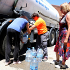 Vecinas de Sarroca de Lleida llenan garrafas de agua potable del camión cisterna