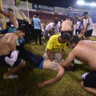 Aficionados y servicios médicos atienden a una persona en el estadio.