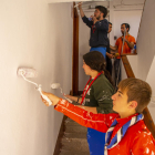 Un grup de joves voluntaris pintant l’escala d’un bloc de pisos a la Mariola.