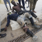 Dos de los migrantes que entraron en Melilla heridos y exhaustos. 