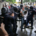 Un home intenta protegir una dona dels cops de porra d'agents antidisturbis de la policia espanyola l'1 d'octubre de 2017.