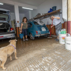 Dos vecinos del barrio de San Ginés de Cartagena retiran el agua de su garaje. 