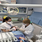 Dos higienistes dentals atenen una pacient.