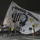 Aficionados del Santos cerca del estadio enarbolan una gran bandera con la efigie de Pelé.