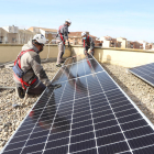 Operarios instalando placas solares en el instituto Maria Rúbies.