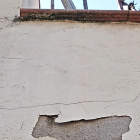 Imagen de la bala que impactó en una vivienda de Malgovern y la marca que dejó en la fachada. 