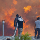 Els residents es protegeixen a la teulada de les cases davant les flames a Gennadi, a l’illa de Rodes.