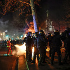 Bomberos apagan un fuego durante las protestas en París el martes por la noche.