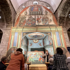 Turistes mirant les pintures col·locades a l’altar major de l’església de la Purificació.