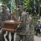 Soldados ucranianos cargan en Kyiv el féretro durante el funeral de un militar caído en combate. 