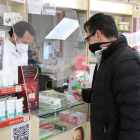 Un usuario comprando cuatro tests de antígenos en una farmacia.