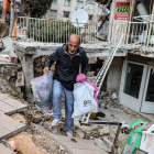 Un home treu unes quantes pertinences de casa, afectada pels terratrèmols.