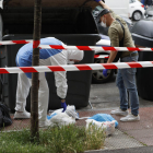 La Ertzaintza buscando pruebas el domingo en unos contenedores cercano al crimen de Vitoria.