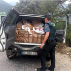 Un agente de la Guardia Civil muestra el maletero de un todoterreno donde han encontrado más de 5.300 paquetes de tabaco de contrabando