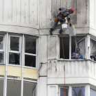 Dos trabajadores reparan un edificio residencial dañado por el ataque en Moscú.