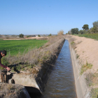 Un agricultor de Arbeca levantando la pala para comenzar a regar desde el canal principal de Urgell, que abrió la campaña ayer. 