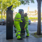 Dos operaris aixequen un parquímetre vell que era al costat d’un de nou, ahir a Cappont.